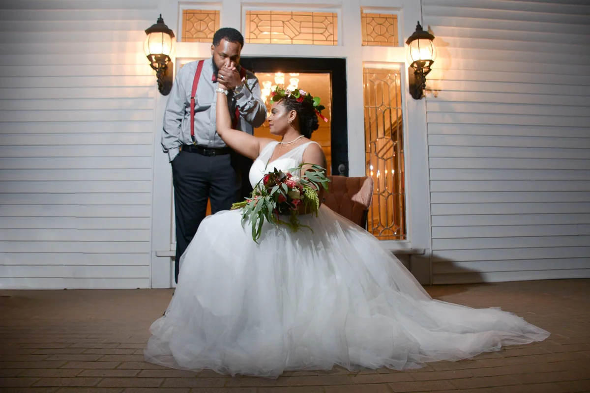B ohemian Styled Shoot bride on chair and groom kissing her hand