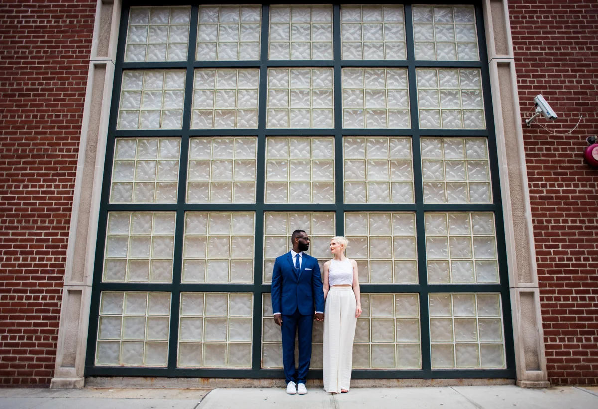 intimate new york elopement couple in front of brick wall set with opaque window grid