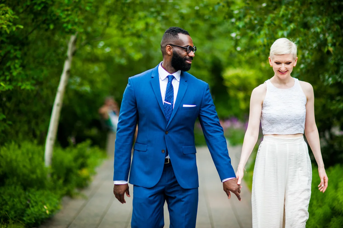 intimate new york elopement holding hands on tree-lined park path