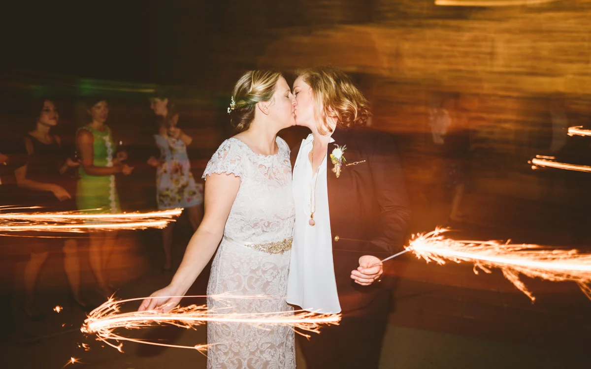 BALTIMORE WEDDING AT MOUNT WASHINGTON MILL DYE HOUSE COUPLE KISSES WHILE HOLDING SPARKLERS