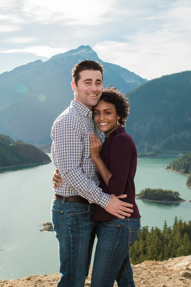 Diablo lake engagement session embrace with mountains and lake in background