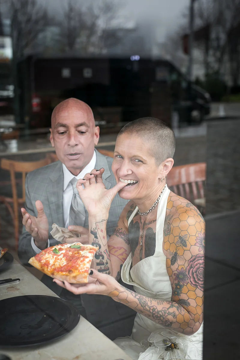 tattooed feminist elopement nyc couple having pizza, inger smiling for camera