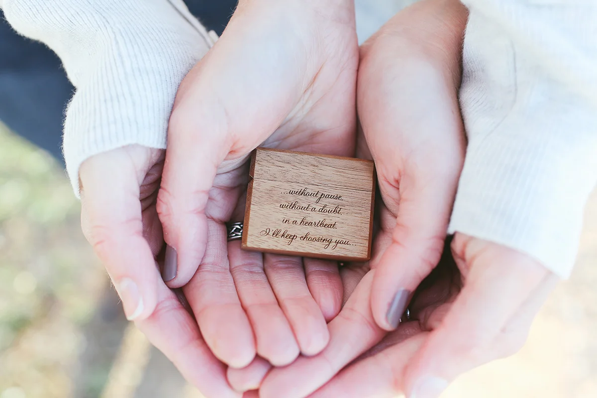 mt. airy north carolina natural engagement ashley and ruthie's hands cradling engraved ring box