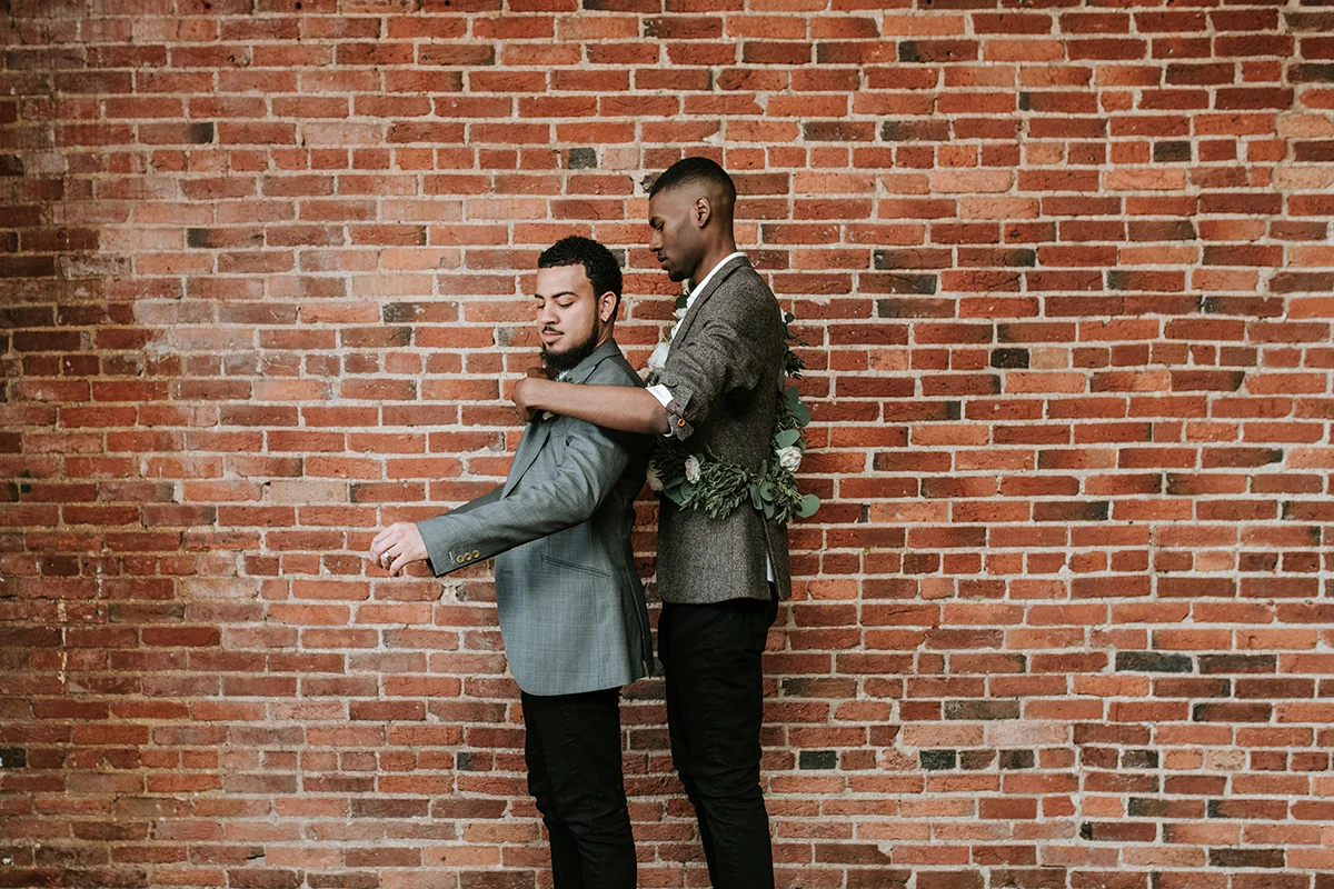 baltimore photo shoot grooms in front of brick wall