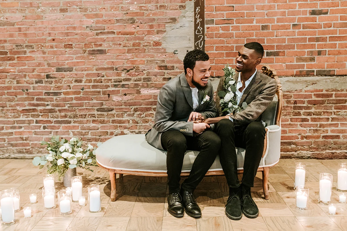 baltimore photo shoot couple laughing on sofa and holding hands