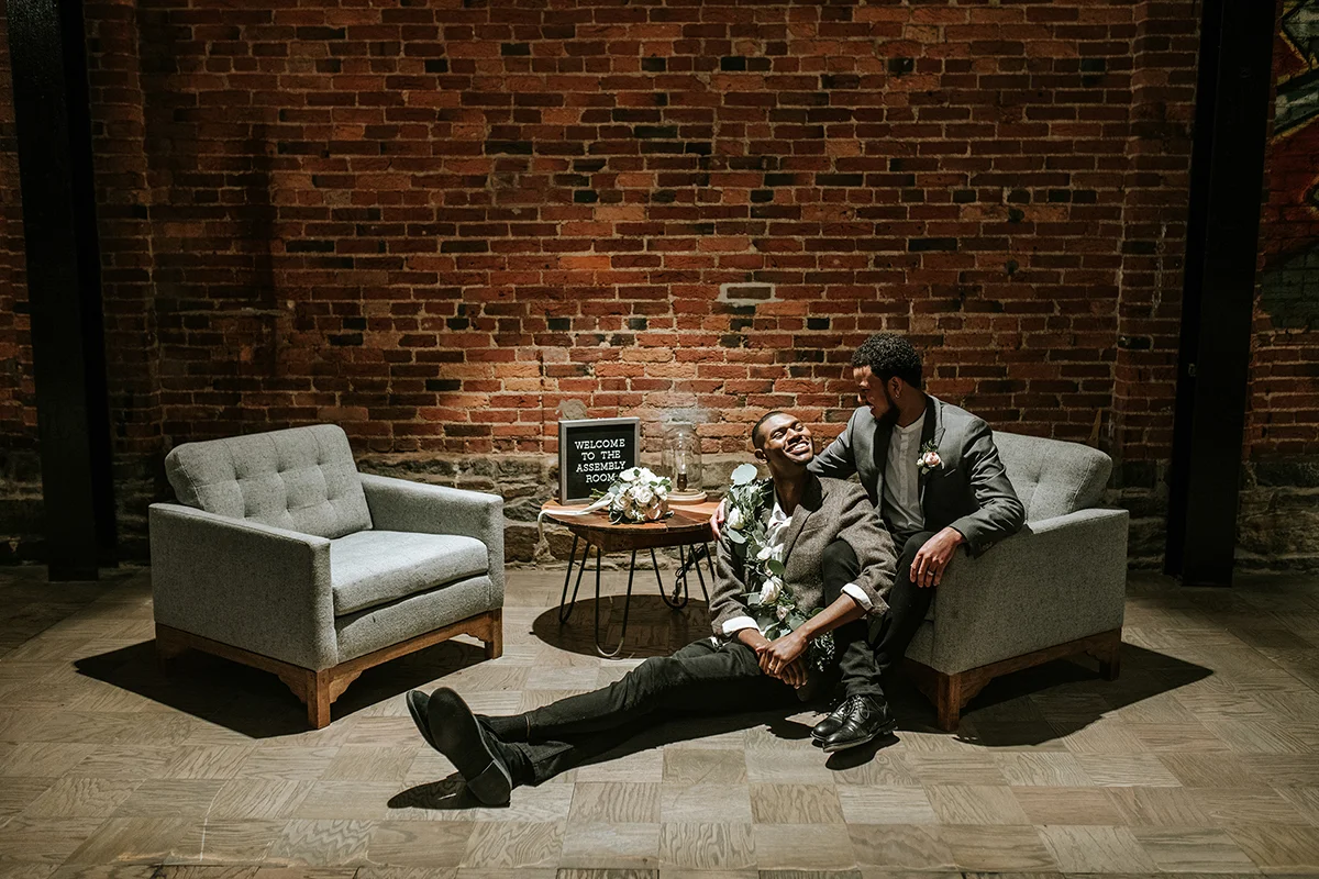 baltimore photo shoot dymir sitting in armchair, hassan on floor in front of him