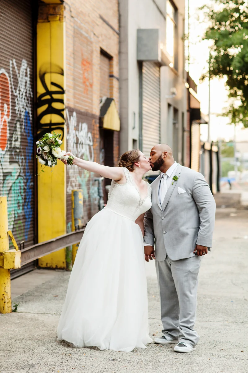 brooklyn bar wedding kiss by graffitied brick