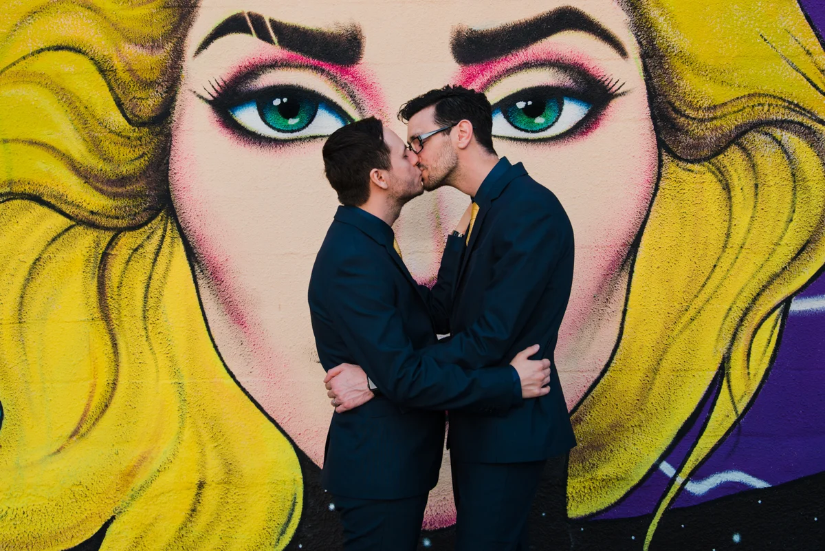 rialto theatre wedding kiss in front of large mural of blonde woman