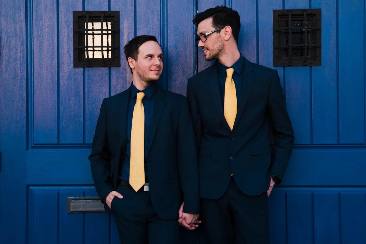 rialto theatre wedding couple holding hands staring at one another in front of brightly painted doors