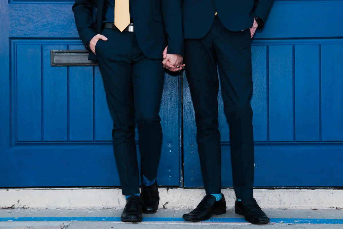 rialto theatre wedding grooms from waist down holding hands in front of doors