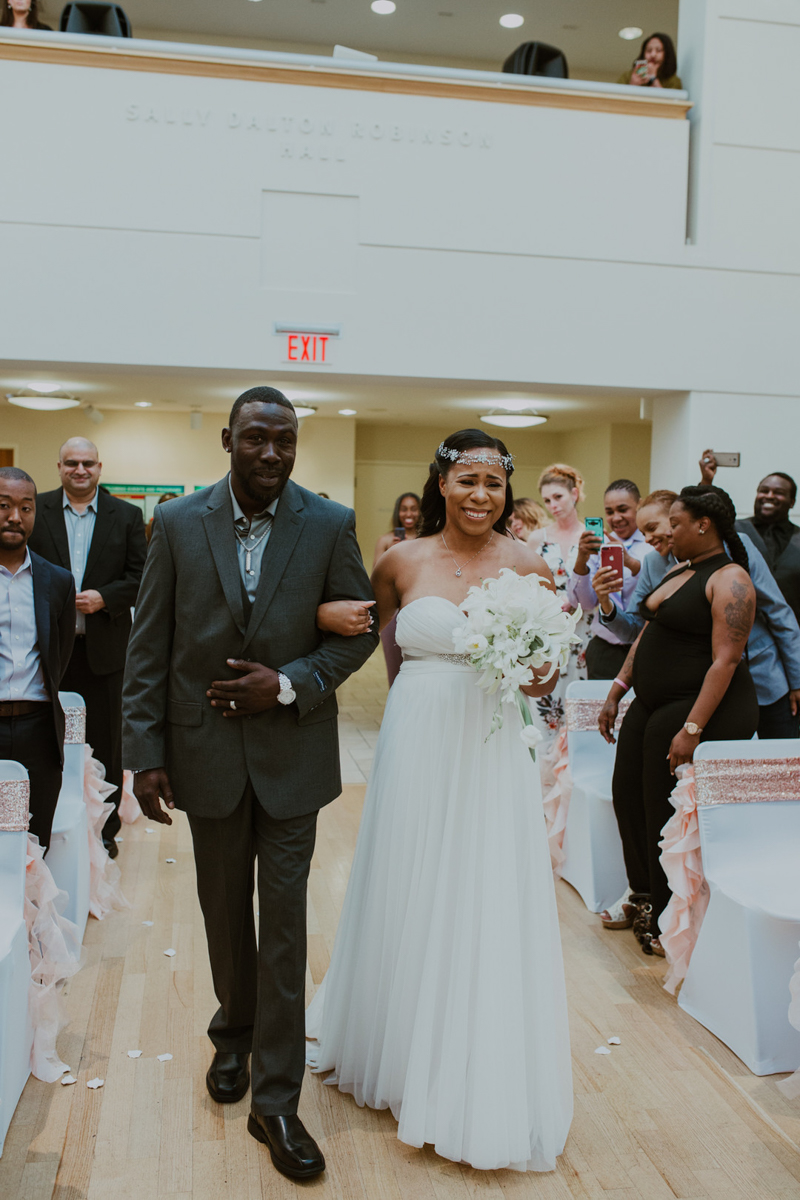 art-inspired levine museum wedding shavonne and father walking down aisle, shavonne emotional and excited guests in background