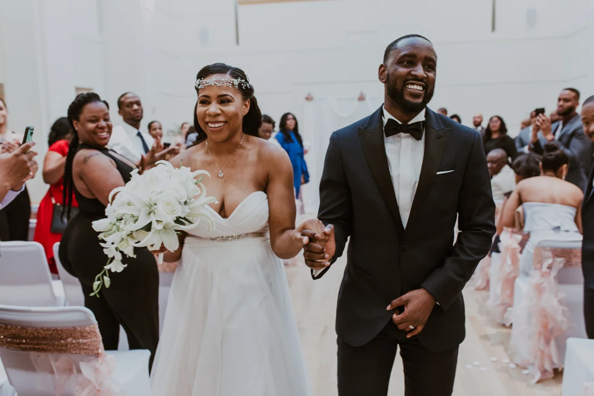 art-inspired levine museum wedding newly married couple walking down aisle holding hands