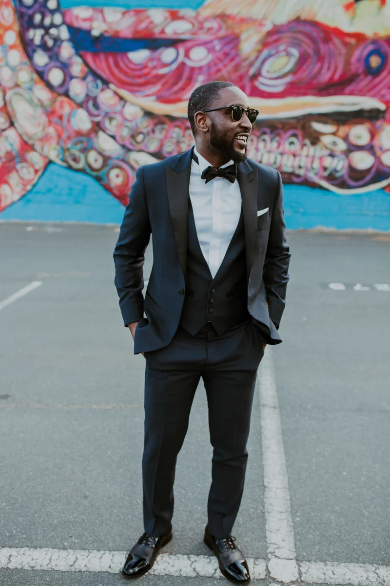 art-inspired levine museum wedding travis wearing sunglasses in front of mural