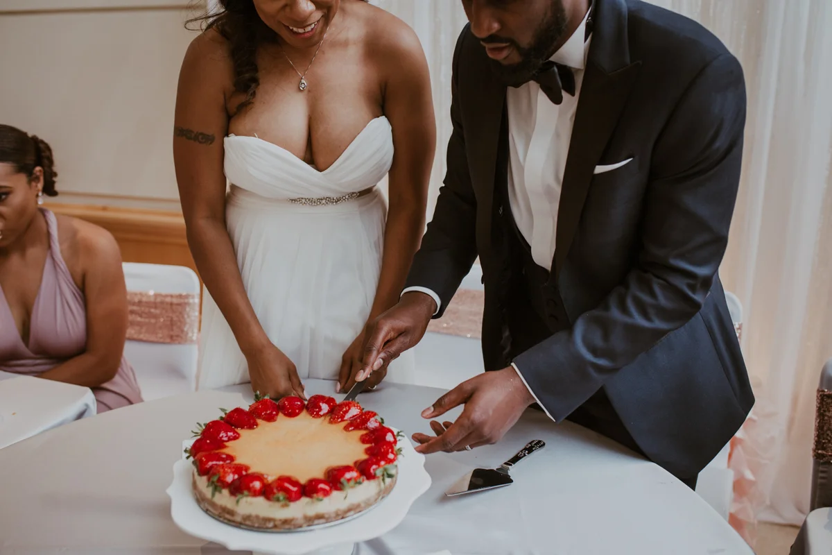 art-inspired levine museum wedding couple cutting cake topped with strawberries