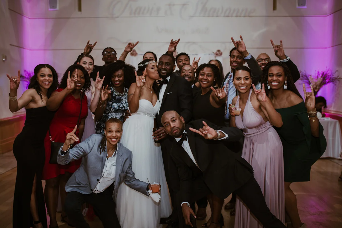 art-inspired levine museum wedding couple and guests together making longhorn hand gesture