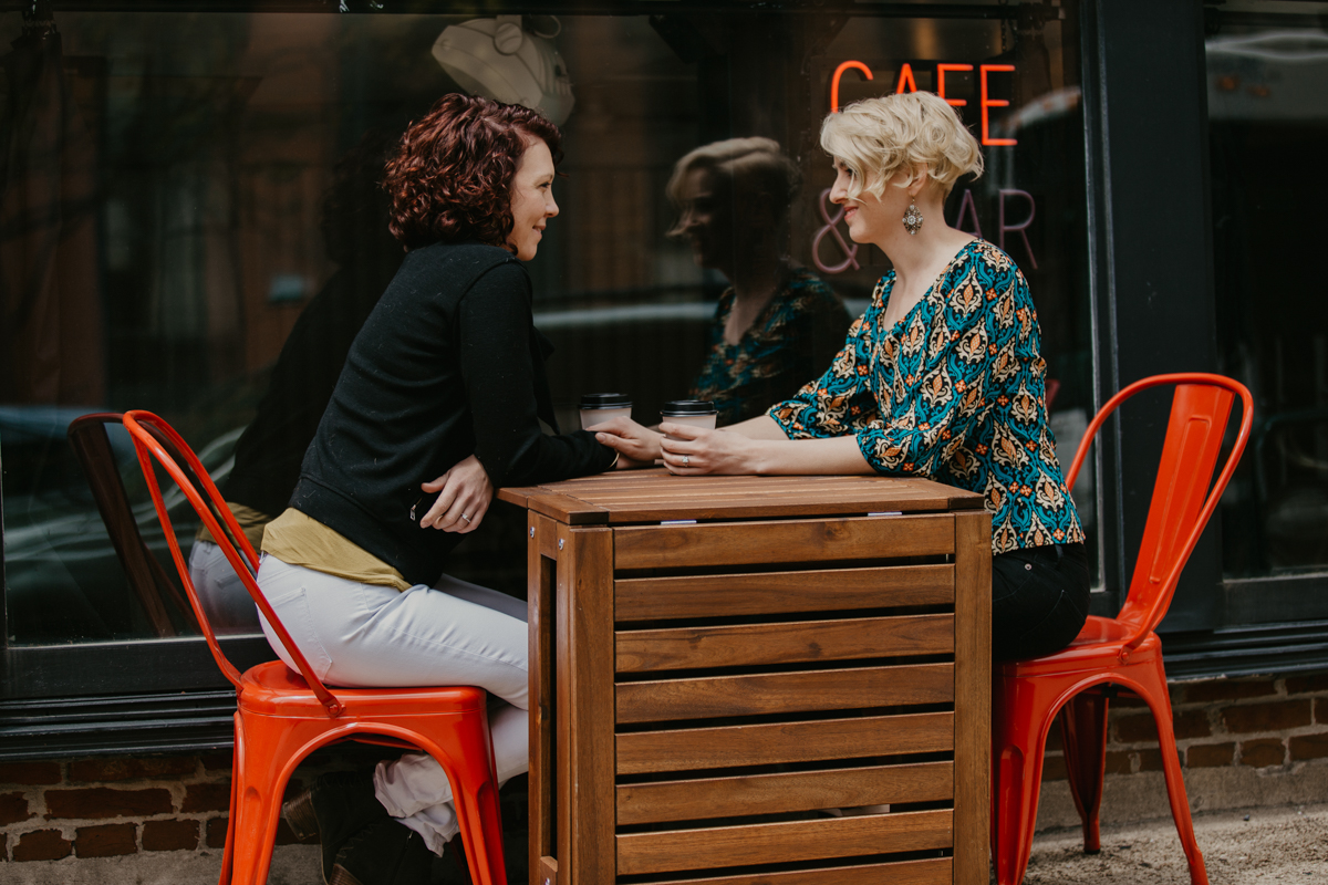  BALTIMORE COFFEE SHOP ENGAGEMENT SESSION COUPLE HOLDING HANDS AT TABLE