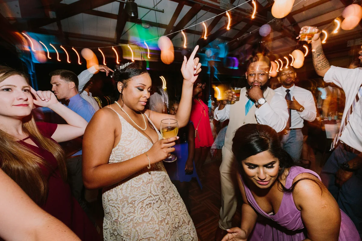 San Diego Tropical-Inspired Wedding janelle on dance floor with guests, lights blurred