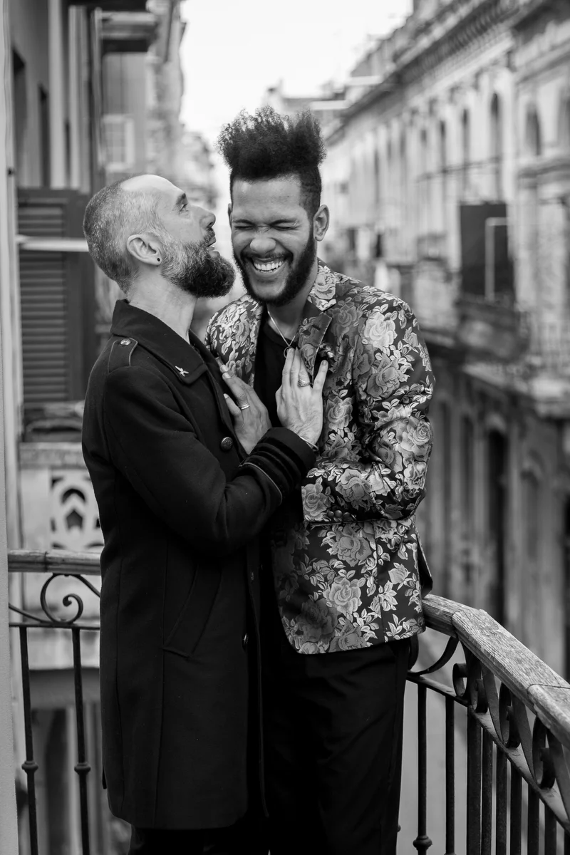 lovers in havana couple on balcony, ishak saying something to make felix laugh