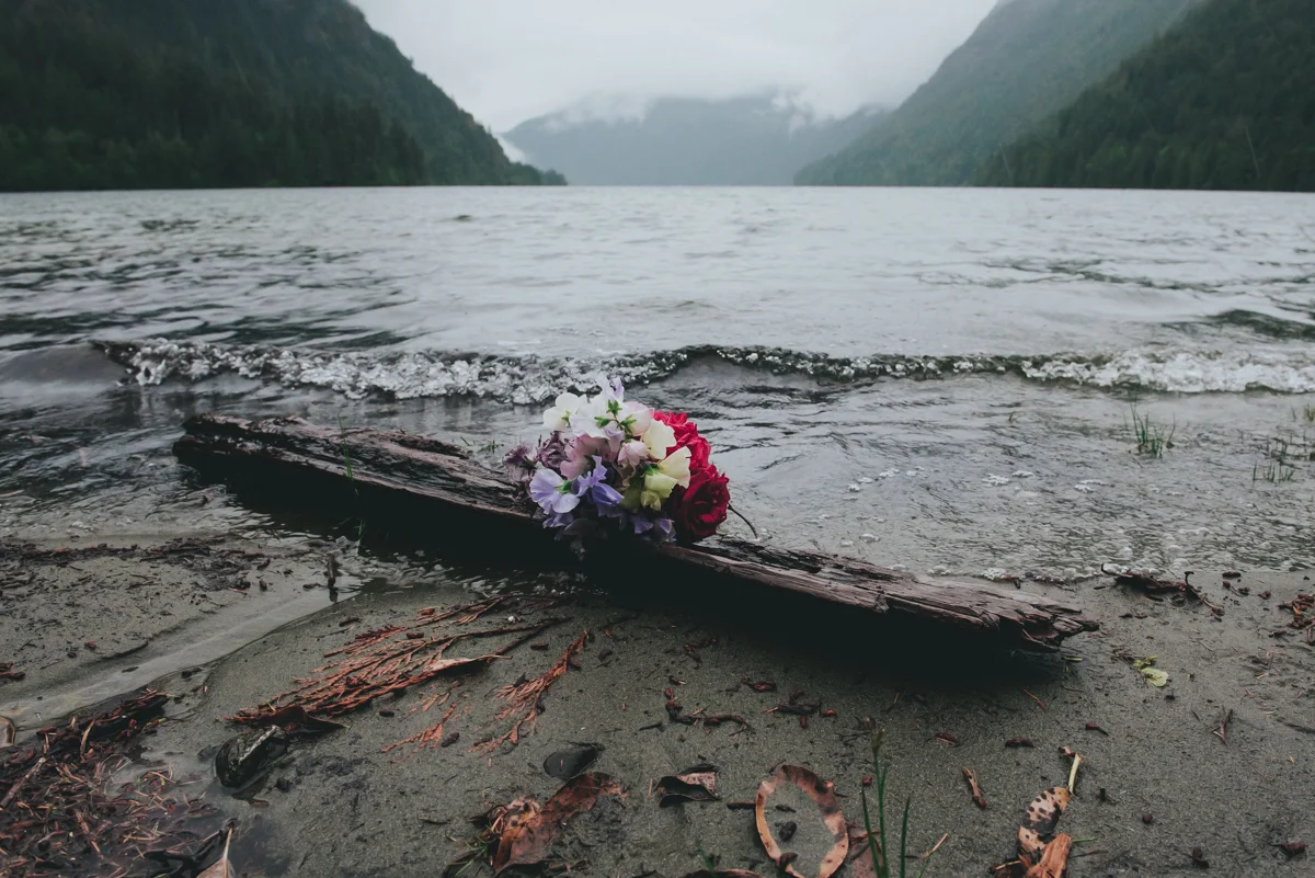 Cameron Lake Photo Session BC Canada bouquet resting on driftwood with wave rolling in from lake