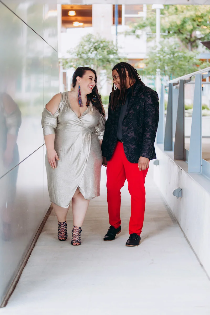 engagement photo shoot at akron art museum alysse and gio laughing and walking on sidewalk outside museum