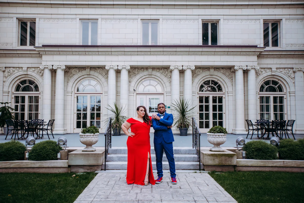 engagement photo shoot at akron art museum couple posing in courtyard wearing elegant suit and dress