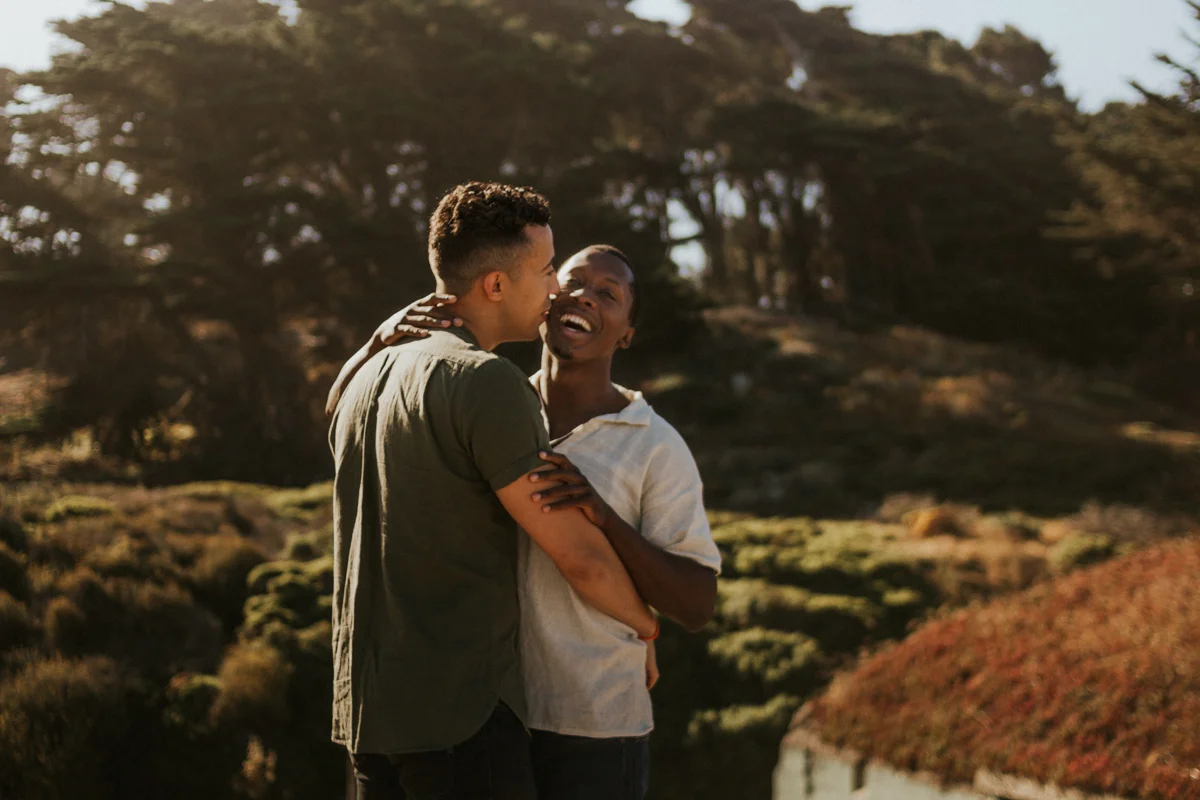 couples session baker beach san francisco california candid of couple laughing and embracing