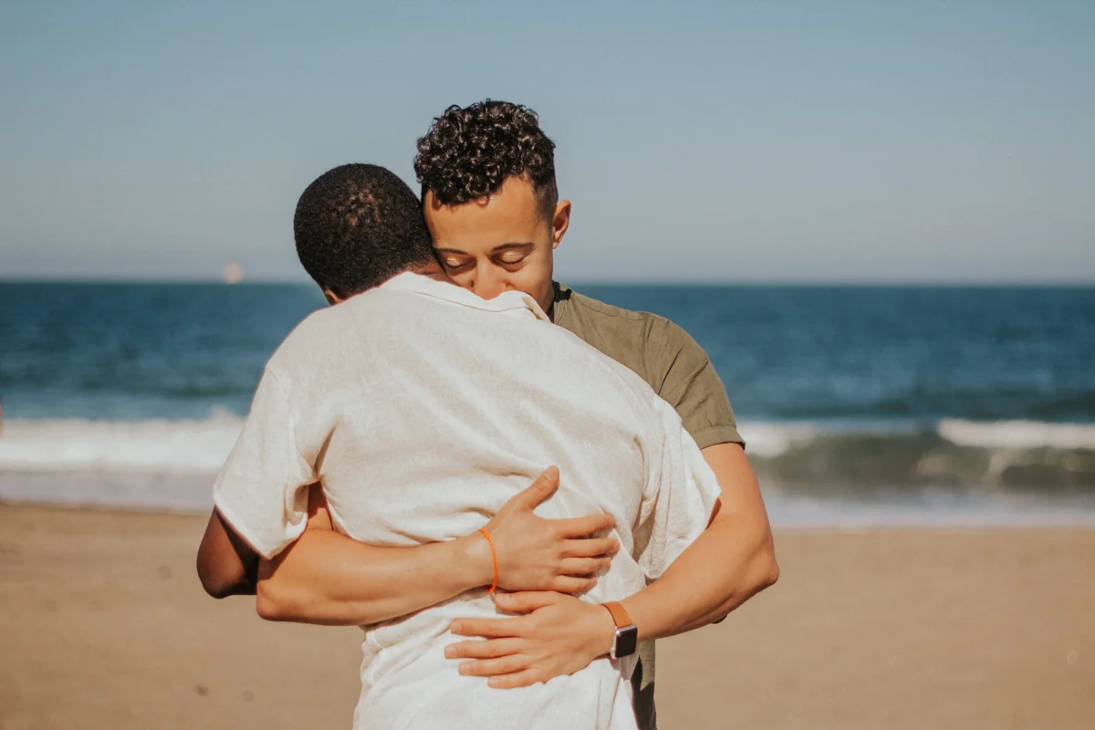 couples session baker beach san francisco california hug on beach with ocean in background
