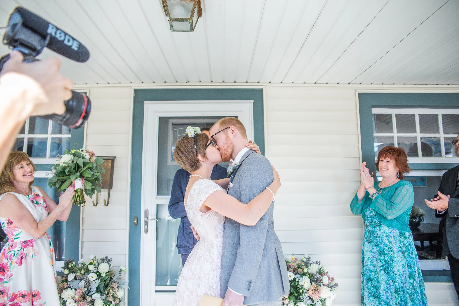 Newlywed couple Bethany and Greg kiss during their front porch ceremony of their Cleveland Ohio home Lea Marie Photography