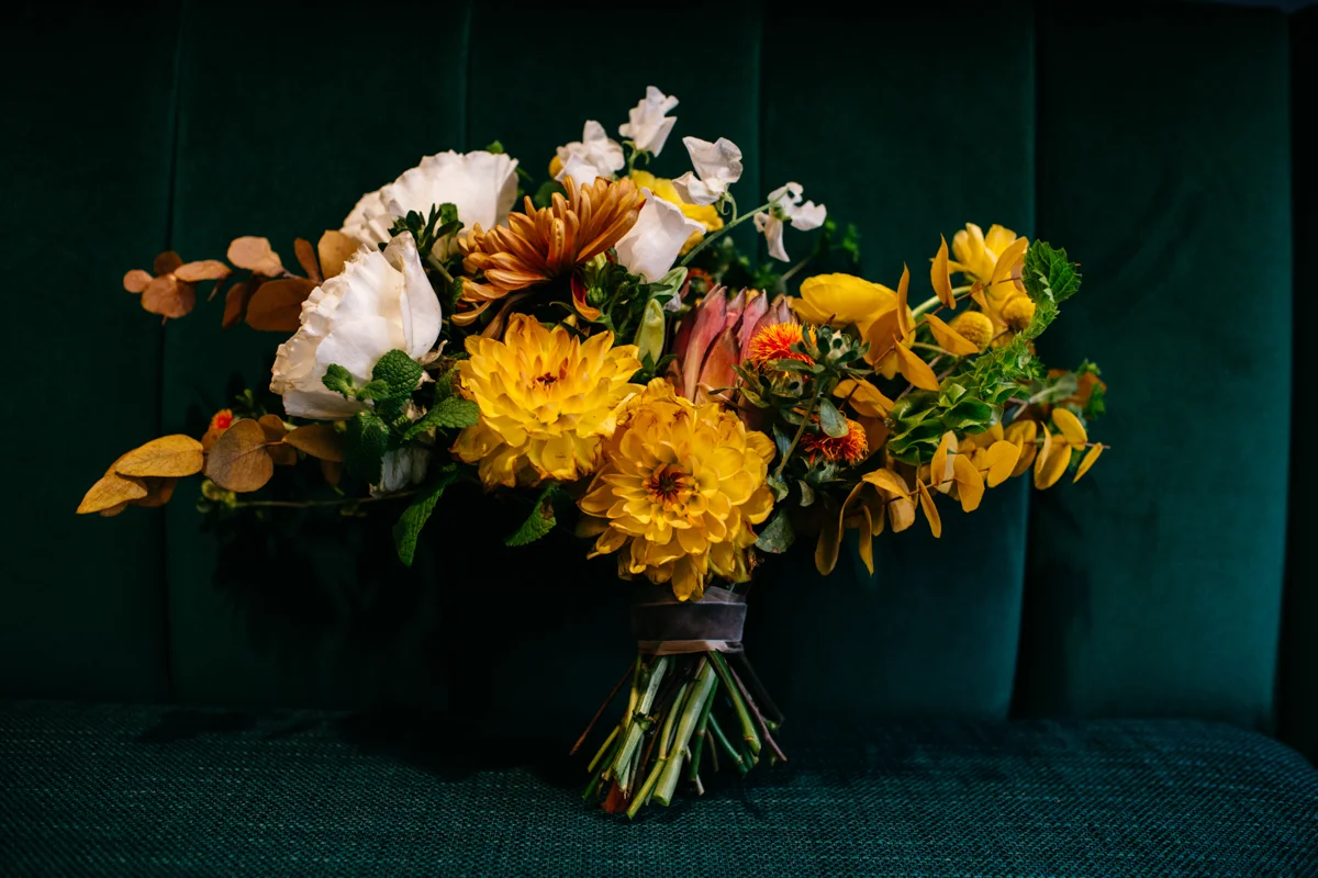 wes anderson inspired wedding styled shoot columbia south carolina colorful bouquet resting on plush seat