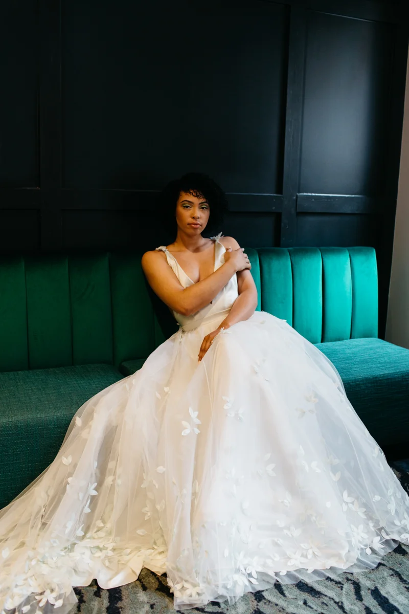 wes anderson inspired wedding styled shoot columbia south carolina bride lounging on bench seat, full shot of gown