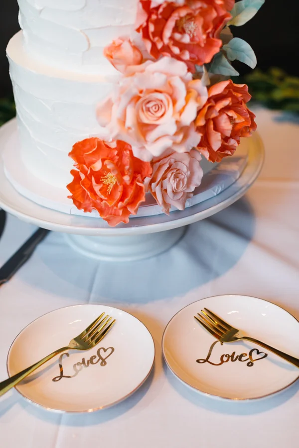 african american, christian, and muslim traditions minneapolis wedding cake with frosted flowers and couples’ plates reading “love”