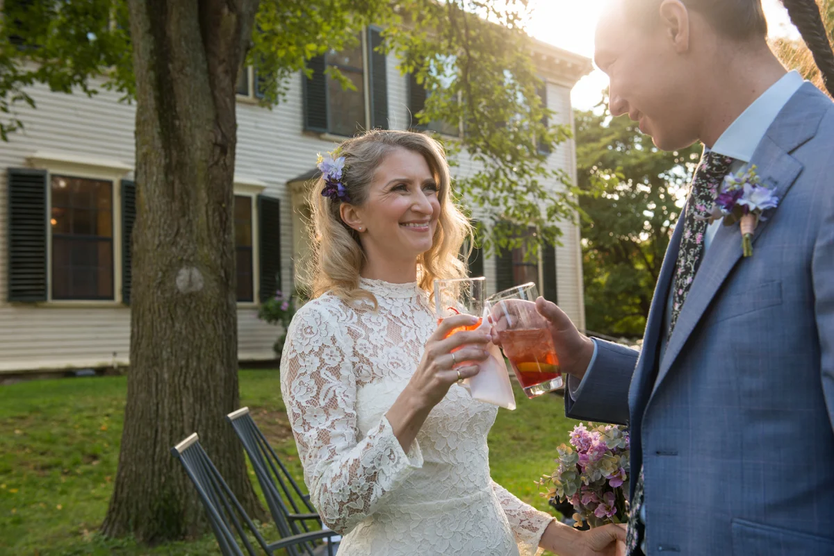 Bride cheersing with groom at their outdoor cocktail reception Leise Jones Photography Boston MA