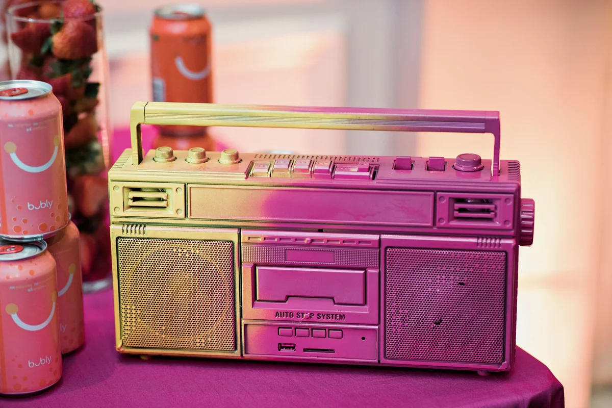 80s themed pride party brooklyn new york iridescent boombox on table with Bubly drinks and tall vase of strawberries