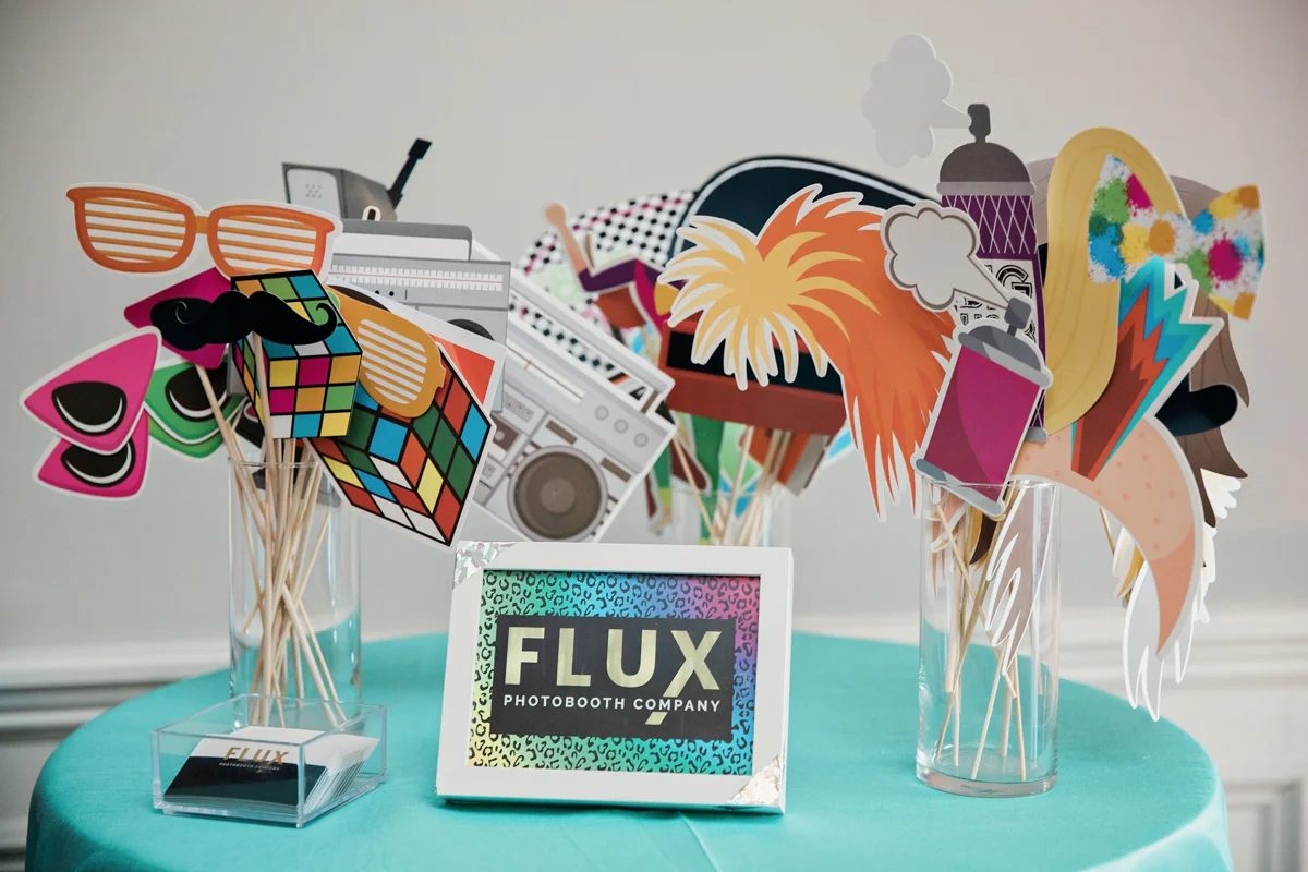 80s themed pride party brooklyn new york table of photo booth props, card reading “flux photobooth company”