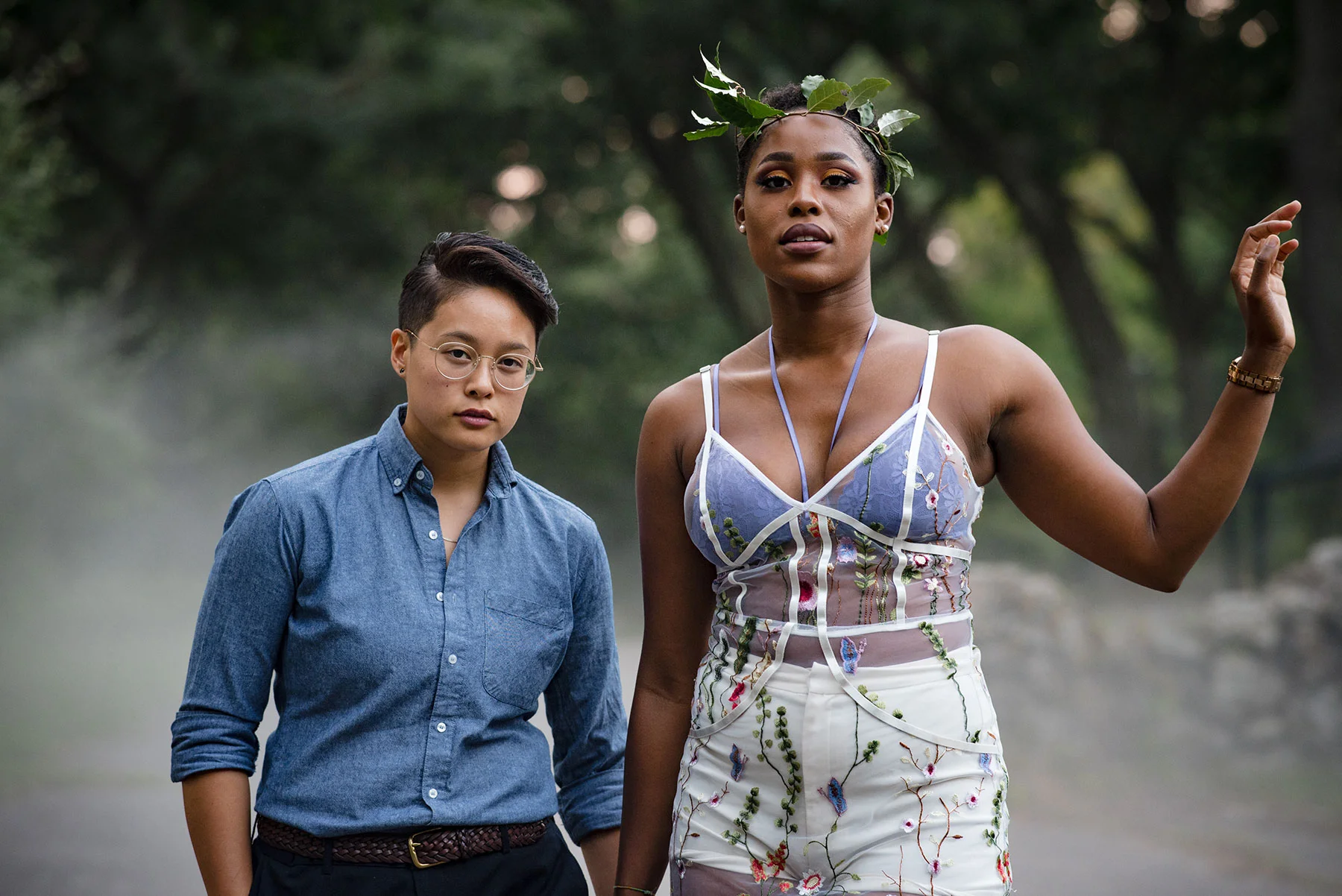 couple posing for engagement photos in casual clothes on path by trees michelle schapiro photography