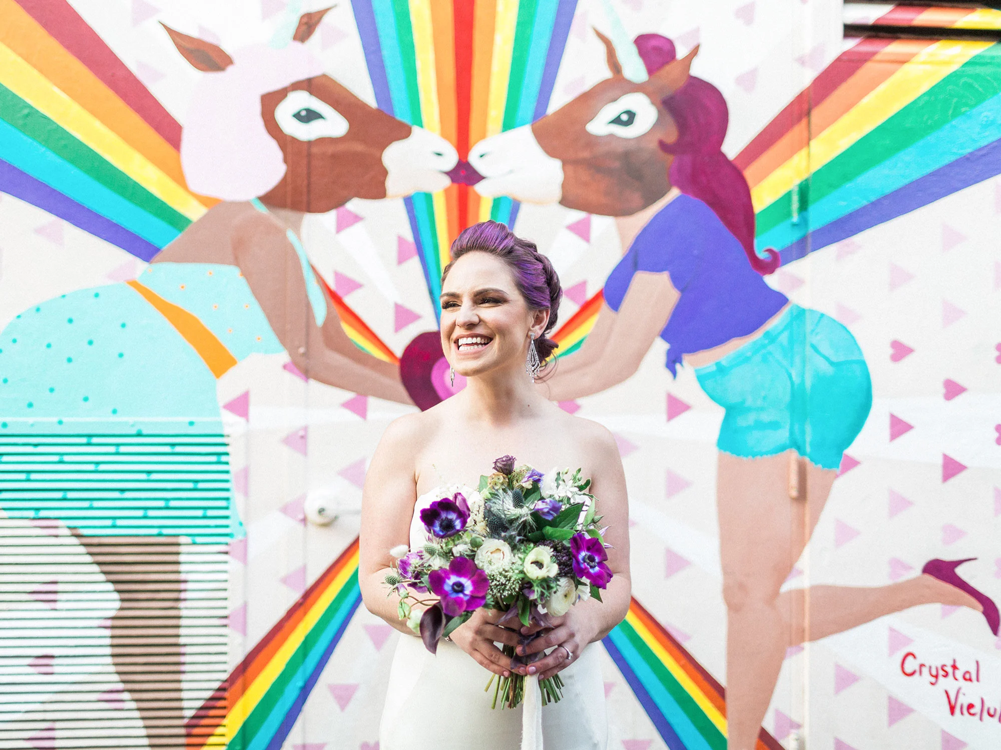 bride holding bouquet in front of rainbow unicorn mural Apollo Fotografie San Francisco