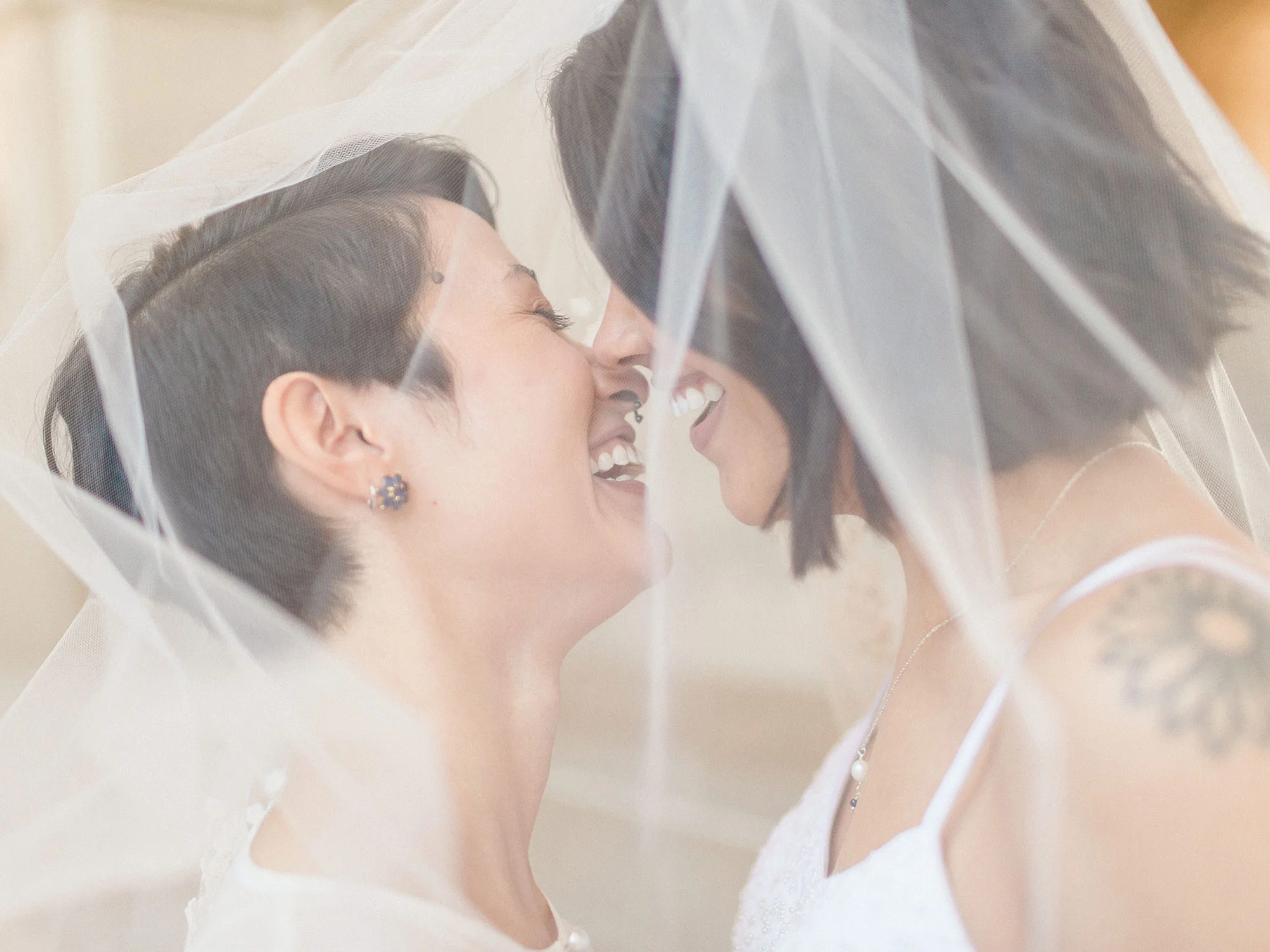 two brides about to kiss under veil at wedding Apollo Fotografie San Francisco