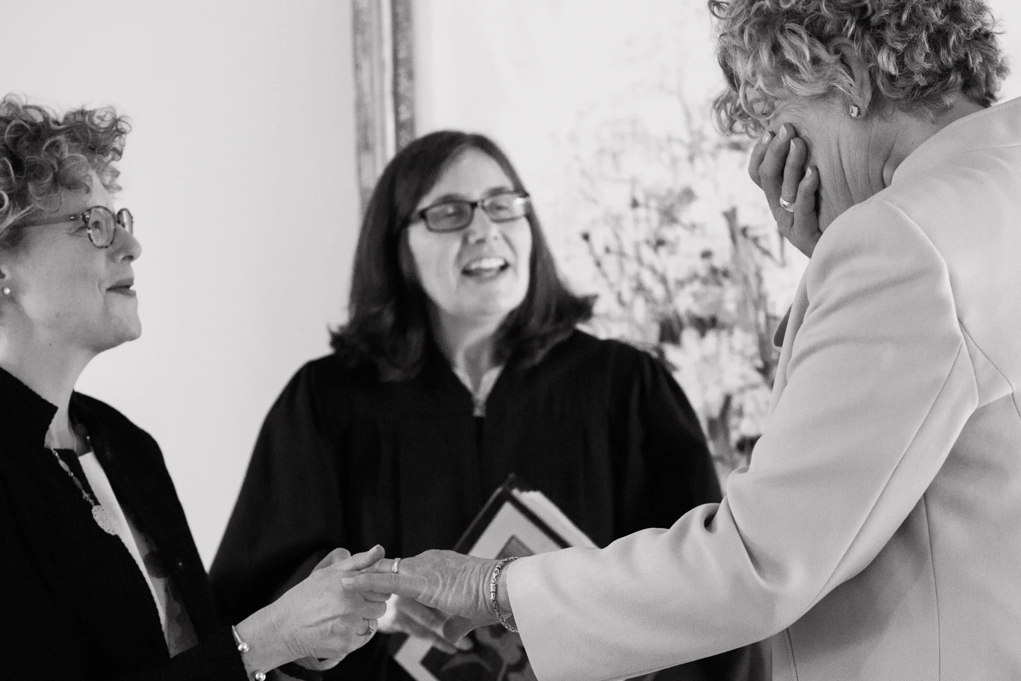 two brides exchanging vows at their wedding ceremony with one bride beginning to cry Meera Graham Photography Missoula Montana