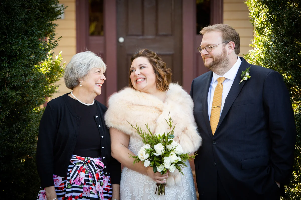 Romantic, Intimate-Feeling Wedding couple and mother in front of hedges