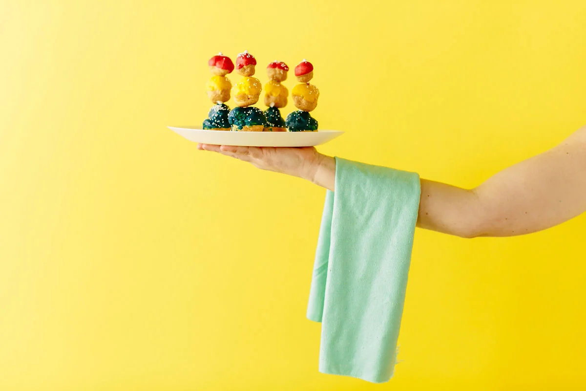 wes anderson inspired wedding brooklyn new york arm with towel draped over it holding desserts against bright yellow background