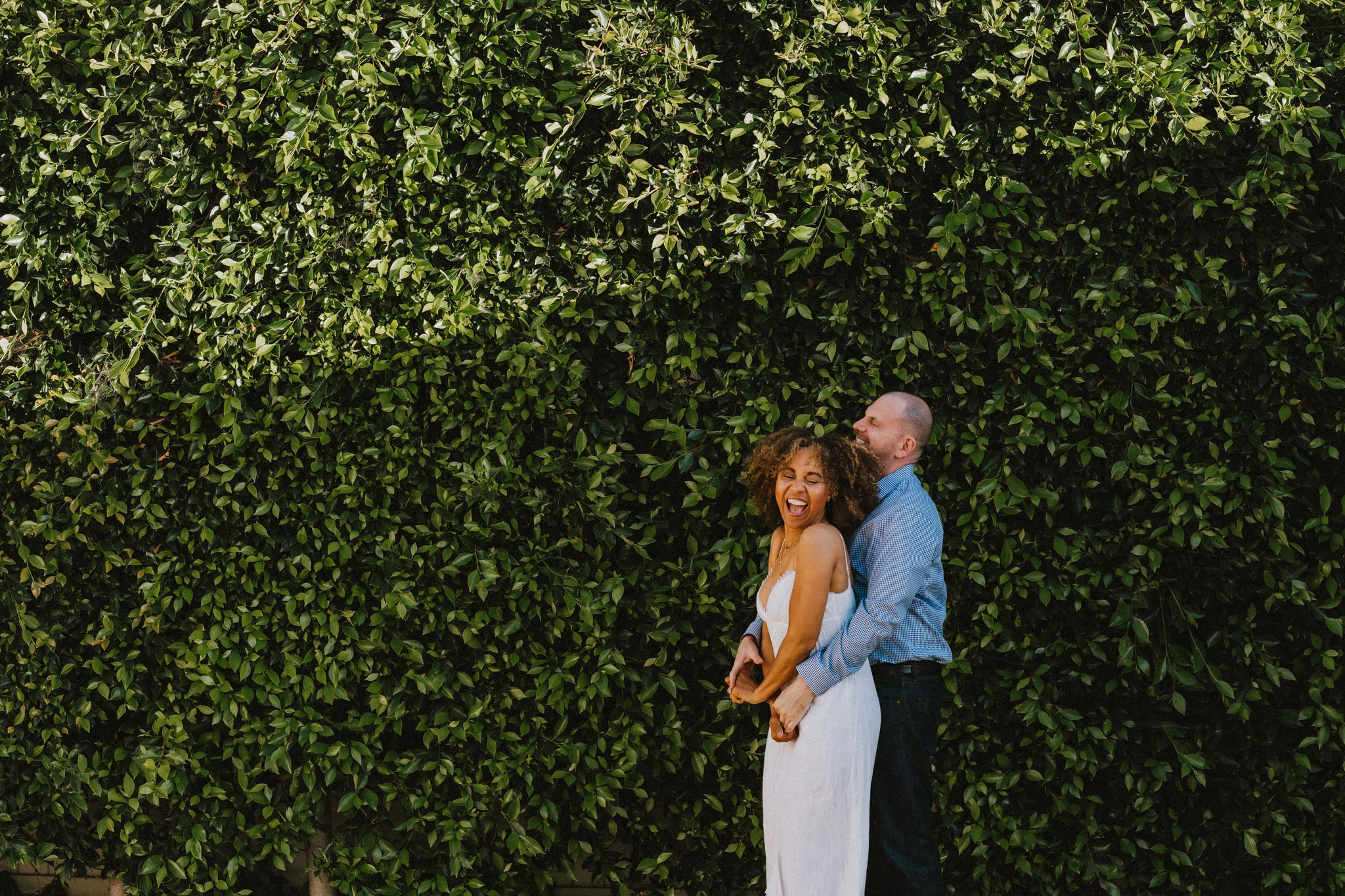 newlywed couple embracing in front of green wall at their wedding by los angeles photographer Rebecca y los otras
