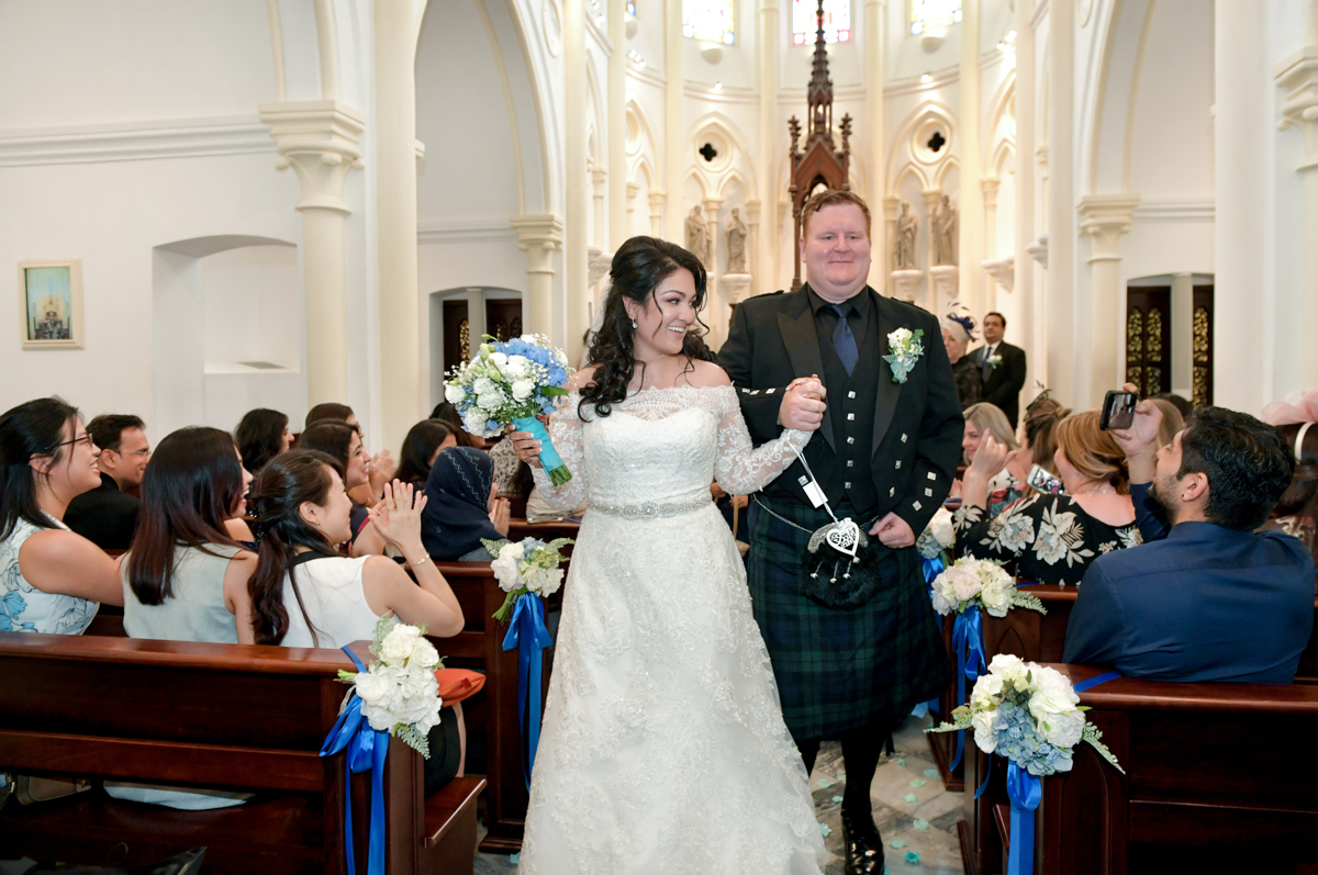 mita in a western wedding dress and james in a scottish kilt walking down the aisle at their western wedding ceremony