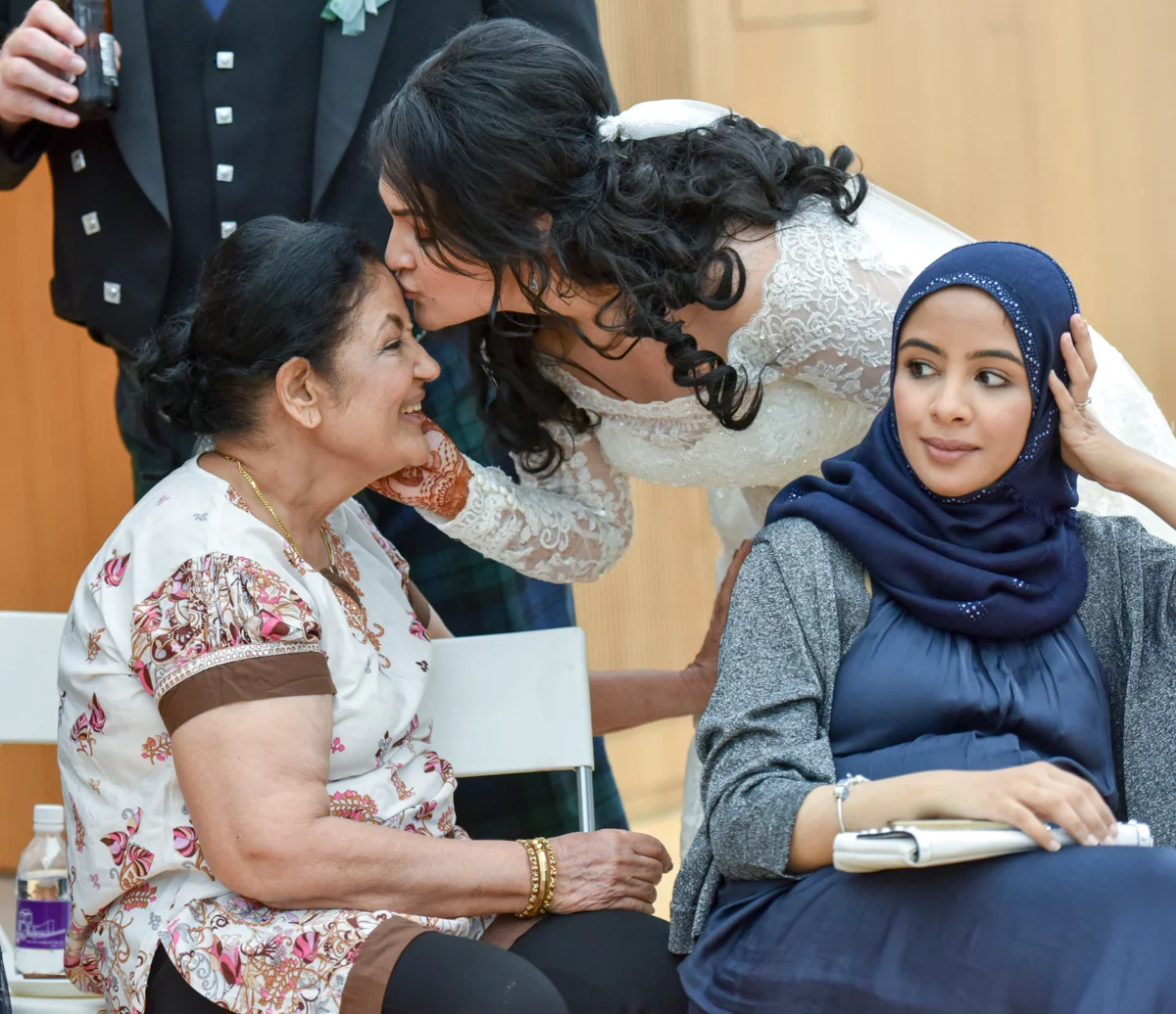 Mita giving her mom a kiss on the forehead at her western wedding ceremony in hong kong
