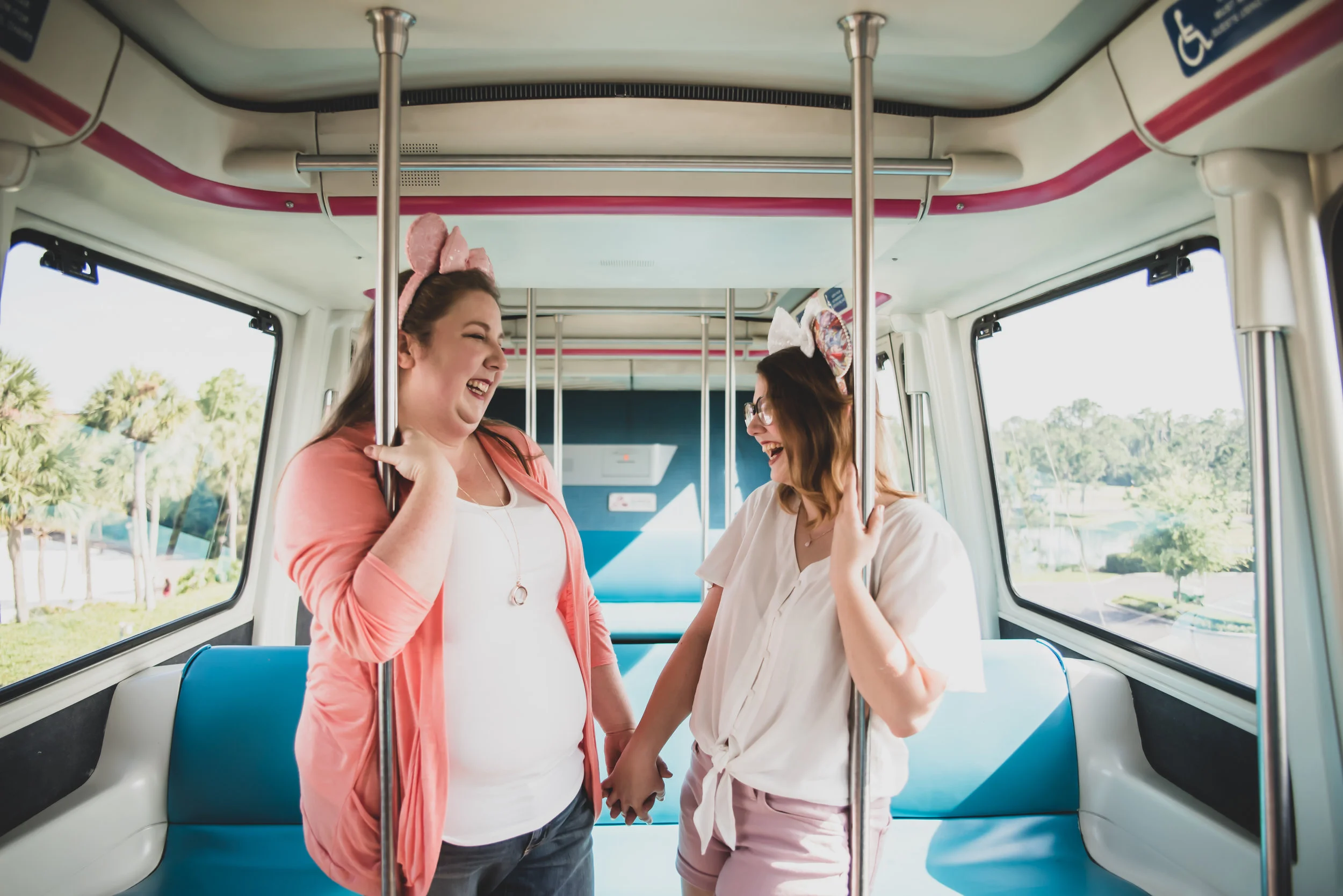 engaged couple holding hands and wearing pink mickey mouse ears Sharma Shari Florida Wedding Photographer