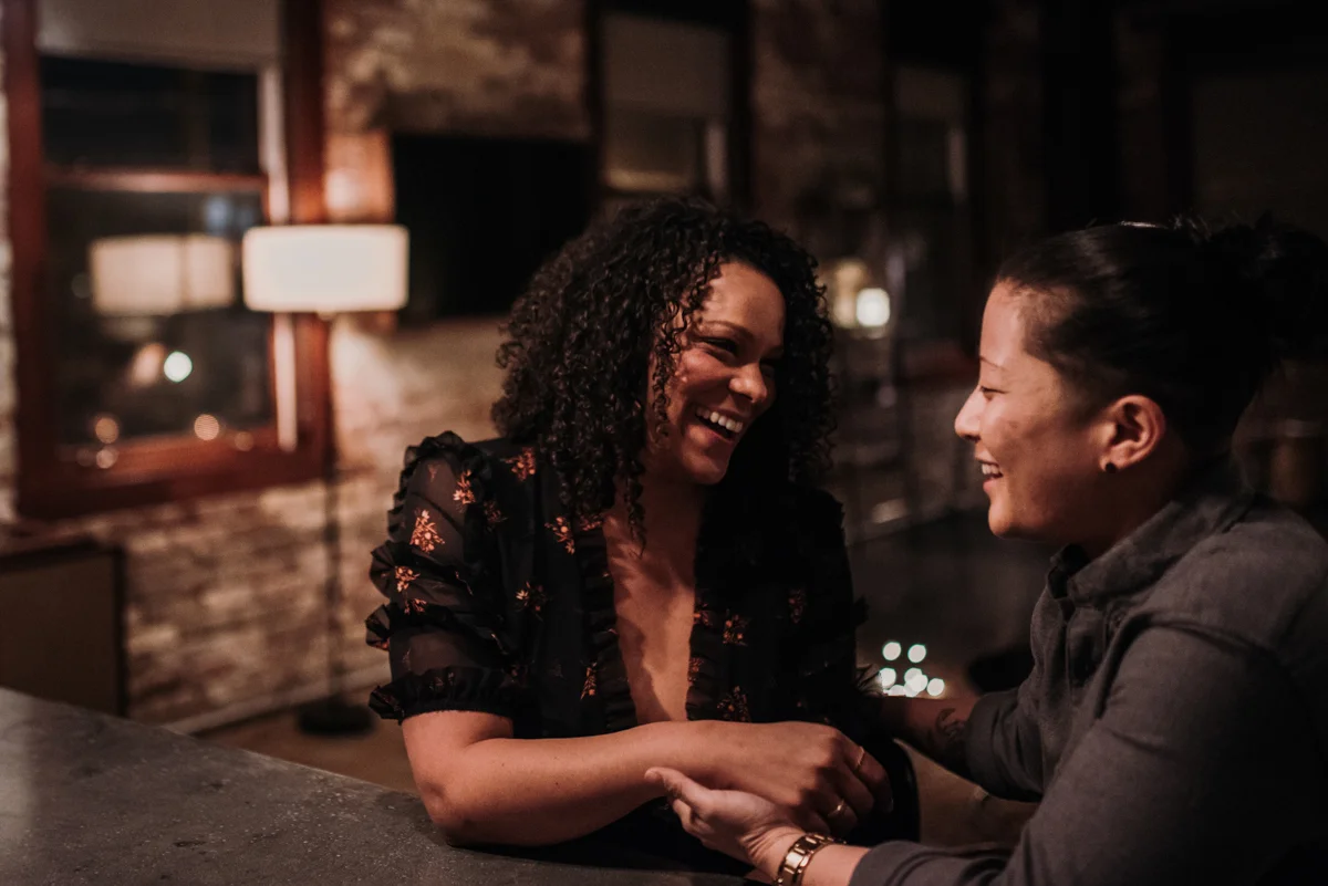 surprise proposal wm. mulherin’s sons hotel philadelphia pennsylvania lauren driscoll photography ashley and kimberly sitting at bar holding hands