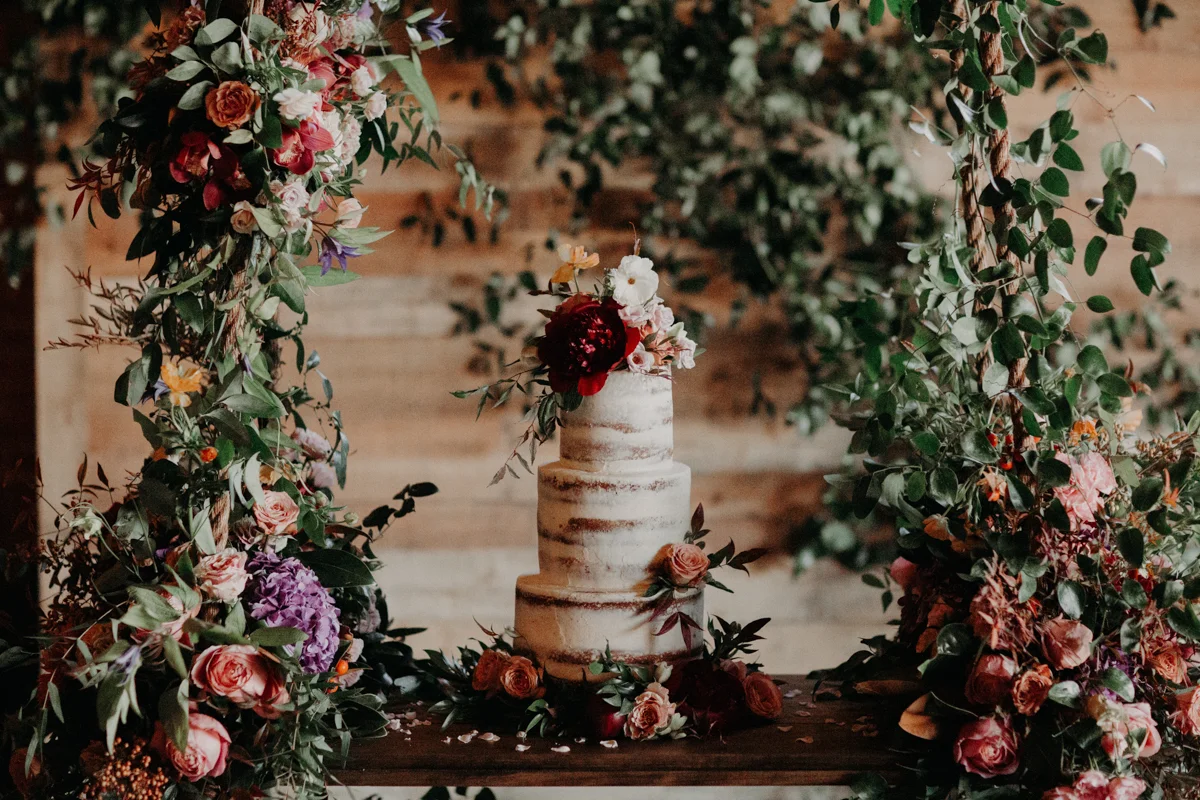 ABBY AND NICK WEDDING AMARILLO TX RITTER COLLECTIVE PHOTOGRAPHY WEDDING CAKE WITH FLOWERS ON SWING