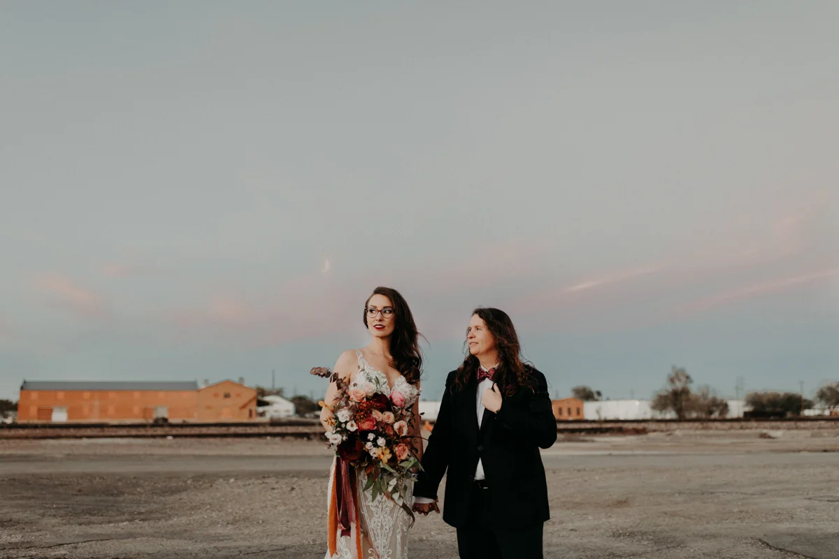 ABBY AND NICK WEDDING AMARILLO TX RITTER COLLECTIVE PHOTOGRAPHY COUPLE IN EMPTY LOT WITH PINK CLOUDS IN SKY