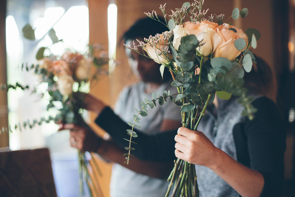 Brides and guests help assemble bouquets before DIY wedding in Colorado Cassandra Zetta Photography