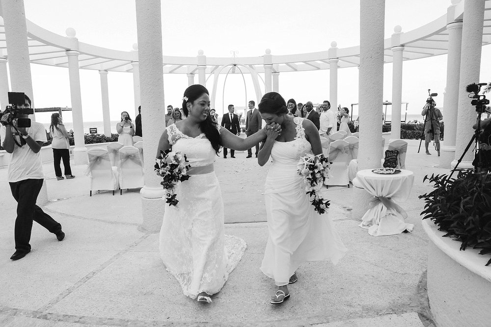 brides exit ceremony holding DIY bouquets Mexico LGBTQ wedding Leah Moyers Photography