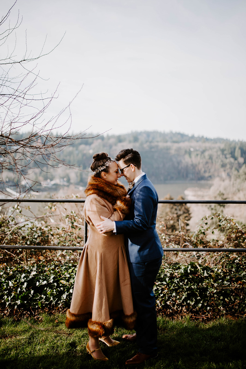 Couple embrace outside home overlooking river before their DIY surprise wedding Jamie Carle